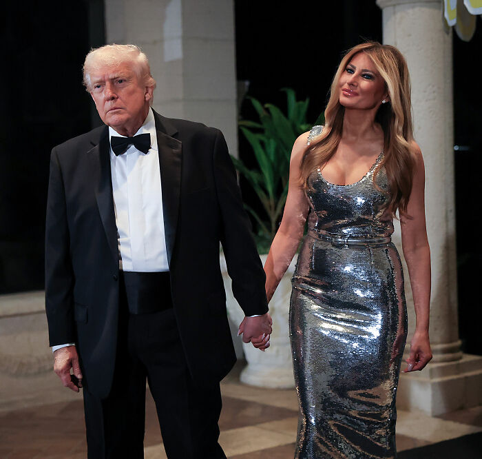 Melania Trump and Donald Trump holding hands at Mar-a-Lago, showcasing Melania Trump's body language during New Year's Eve event. Melania Trump and Donald Trump holding hands at Mar-a-Lago, showcasing Melania Trump's body language during New Year's Eve event.