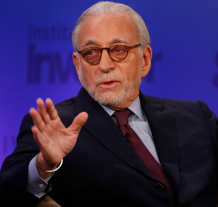 Older man with glasses and gray hair speaking and gesturing during a formal event about Brooklyn Beckham and Nicola Peltz theories. Older man with glasses and gray hair speaking and gesturing during a formal event about Brooklyn Beckham and Nicola Peltz theories.