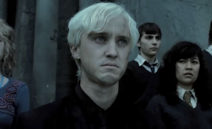 Character Draco Malfoy with pale hair and dark clothing, representing famous villains in the discussion of Lord Voldemort pure evil.