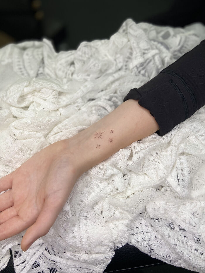 Minimalist star tattoos on a wrist, showing cool tattoos that look almost unreal with delicate fine lines.
