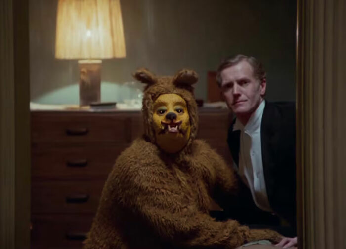 Person in dog mask costume with another man in formal attire at a creepy Mar-a-Lago event setting. Person in dog mask costume with another man in formal attire at a creepy Mar-a-Lago event setting.