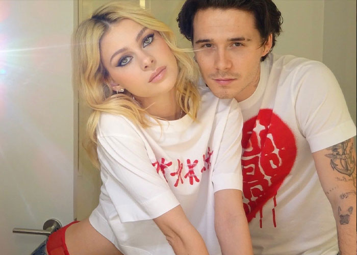 Blonde woman and man wearing white shirts, posing closely indoors with soft natural light in casual setting. Blonde woman and man wearing white shirts, posing closely indoors with soft natural light in casual setting.