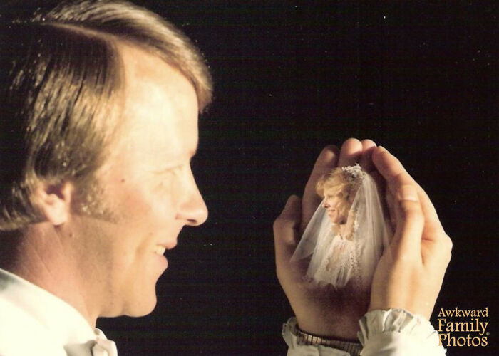 Man smiling while holding a tiny bride illusion in his hands in one of the most awkward wedding photos.