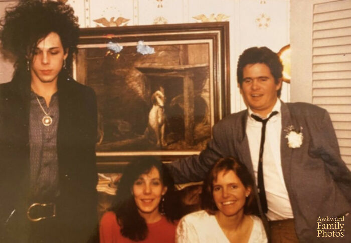 Four people posing awkwardly indoors in a vintage setting, illustrating awkward wedding photos with unintentional humor.