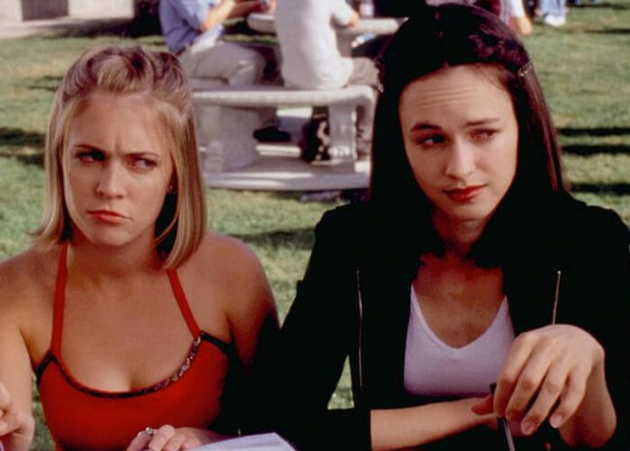 Nickelodeon star and Britney Spears sitting outdoors, showing emotional expressions in a candid moment.