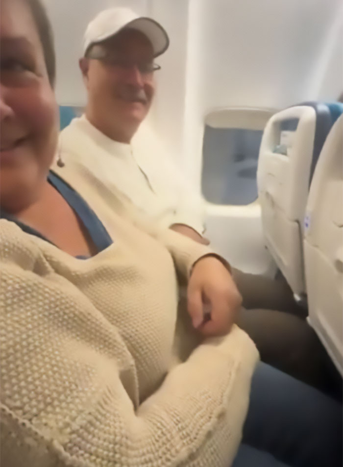 Passengers in sardine can seating, two people squeezed in narrow airplane seats with little legroom Passengers in sardine can seating, two people squeezed in narrow airplane seats with little legroom