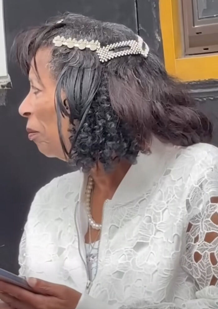 Woman with a unique and disastrous hairstyle featuring mixed textures and decorative hair clips wearing a white lace top.