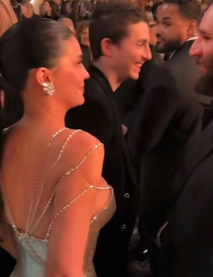 Kylie Jenner and Timothée Chalamet at Golden Globes event with other stars in a dimly lit social setting. Kylie Jenner and Timothée Chalamet at Golden Globes event with other stars in a dimly lit social setting.