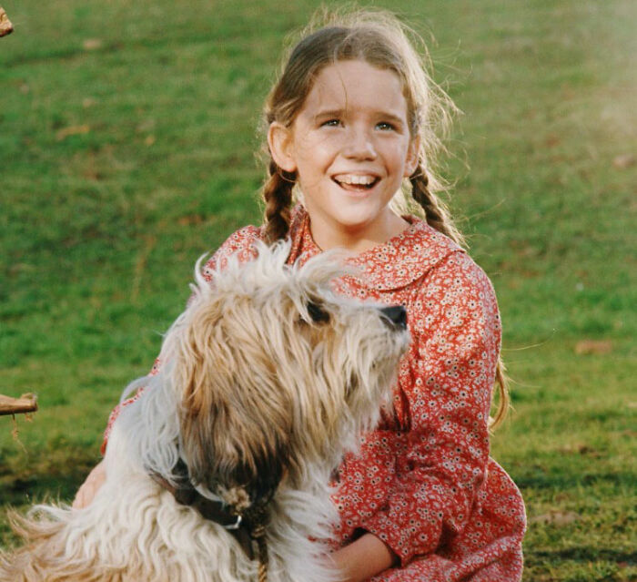 Young girl smiling outdoors with dog, unrelated to Melissa Gilbert sparks outrage Instagram fridge tour news.