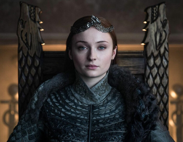 Sophie Turner in character showcasing her ripped Lara Croft transformation for Tomb Raider with a serious expression.