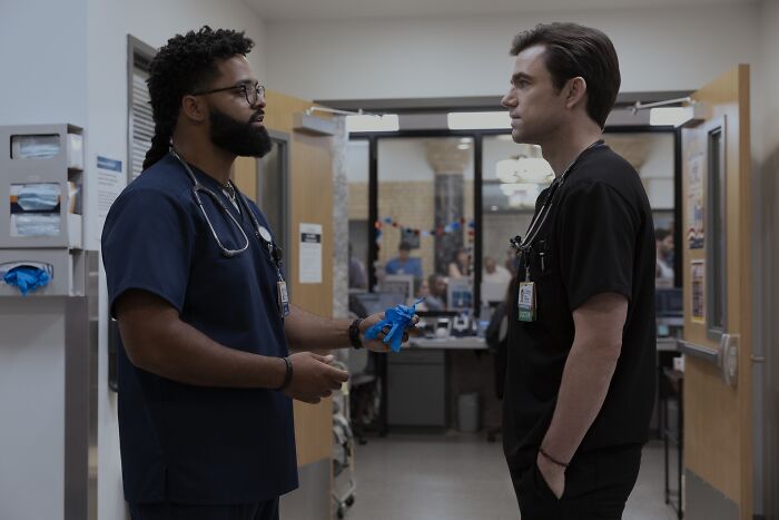 Two healthcare professionals in hospital scrubs discussing MRSA infection risks in a clinical setting at The Pitt hospital. Two healthcare professionals in hospital scrubs discussing MRSA infection risks in a clinical setting at The Pitt hospital.