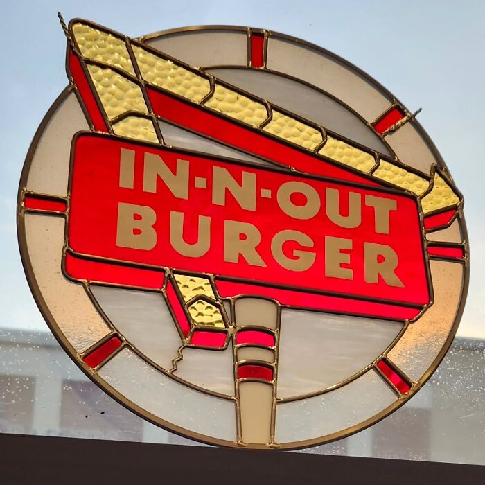 Stained glass sign of In-N-Out Burger logo with vivid colors, showcasing pop culture icons in artistic design.