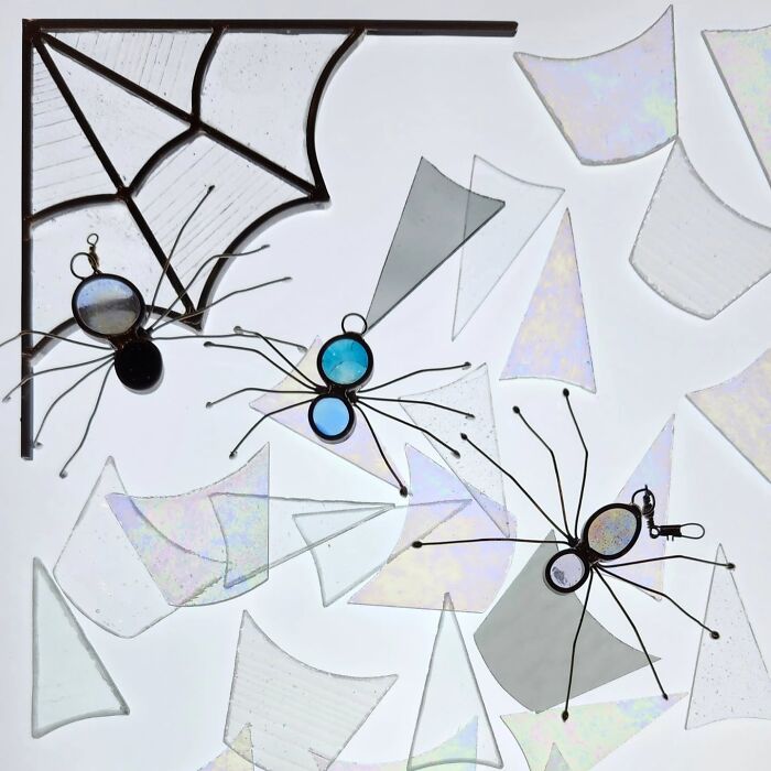 Vivid stained glass art featuring pop culture inspired spider designs with colorful glass and wire details.