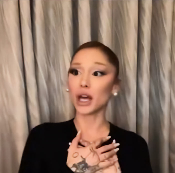 Ariana Grande with expressive hand gestures and unusual facial expressions in a recent interview sparking bizarre mannerisms theories. Ariana Grande with expressive hand gestures and unusual facial expressions in a recent interview sparking bizarre mannerisms theories.