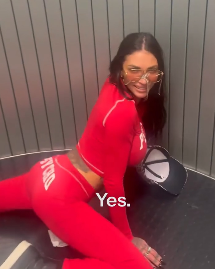 Woman in red outfit smiling inside an airplane elevator linked to adult stars arrested and first-class seat incident. Woman in red outfit smiling inside an airplane elevator linked to adult stars arrested and first-class seat incident.