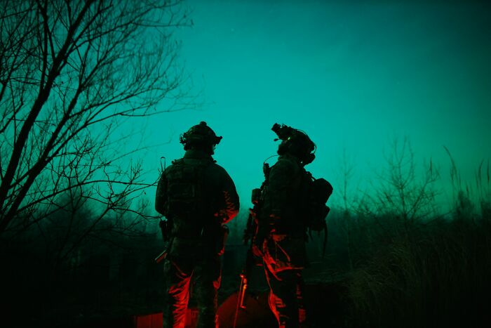 Two soldiers in tactical gear standing in eerie low light, evoking terrifying real-life moments like a horror movie scene.