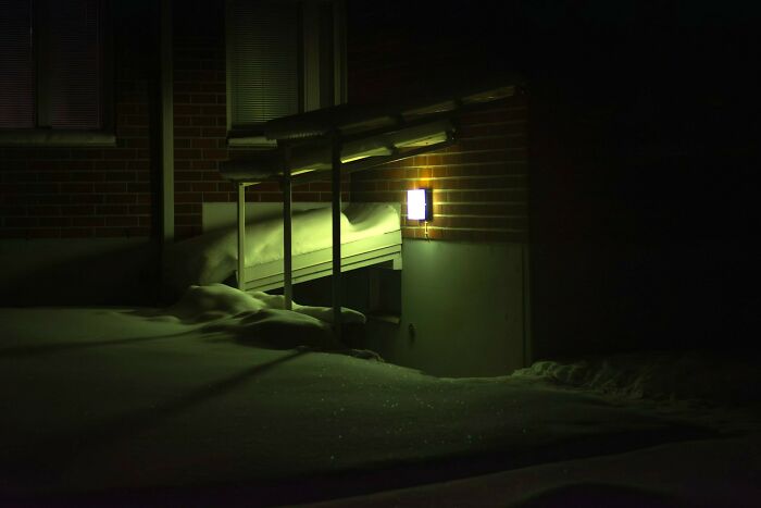 Outdoor light illuminating a snow-covered entrance at night, illustrating safety measures women use while living alone.