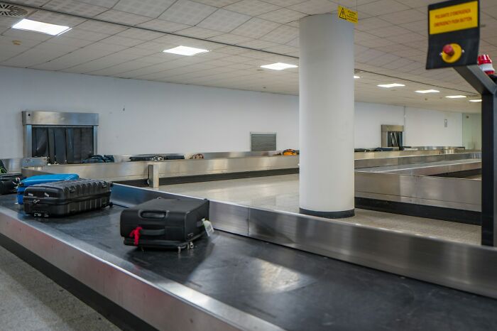 Airport luggage conveyor belt with suitcases, illustrating shipping containers and simple logistical solutions.