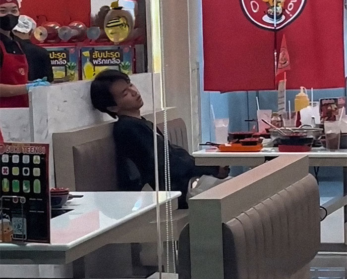 Customer asleep at all you can eat buffet while employees witness unusual gluttony and restaurant chaos around tables.