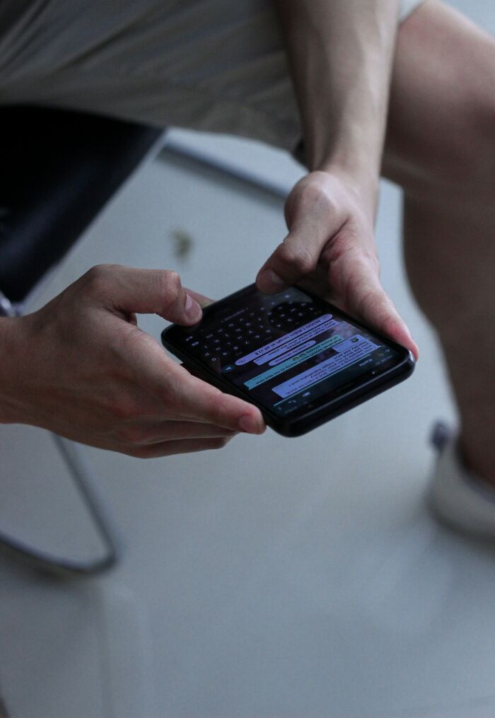 Person holding smartphone and texting, illustrating normal practices in Europe people in the US may find weird.