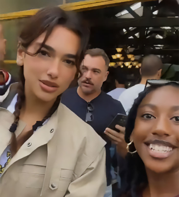 Dua Lipa posing with a South African fan who used a filter on their selfie during a casual outdoor meetup.