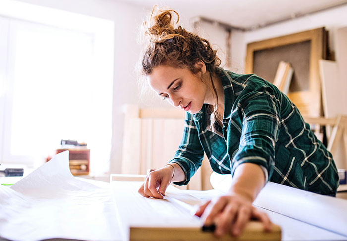 Young woman focused on woodworking project, applying easy skills to improve her life and build a better future.