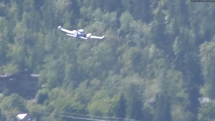 Small white airplane flying over dense green forest, illustrating one of the biggest unsolved cases from around the world.