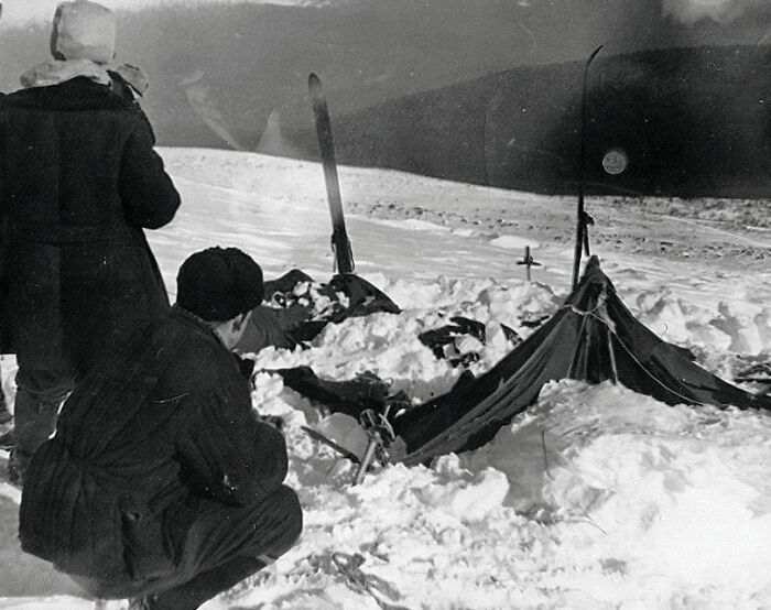 Two men investigate a snow-covered campsite with a damaged tent, part of one of the biggest unsolved cases worldwide.