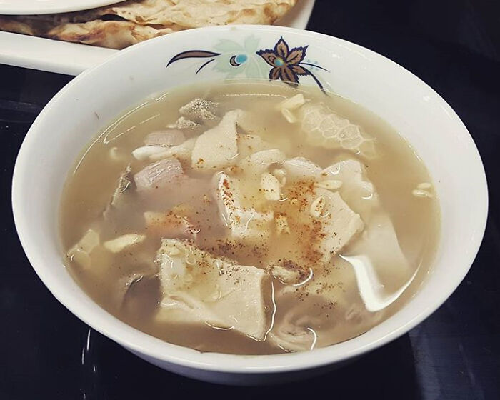 Bowl of unusual local delicacy soup with tripe and spices, showcasing a disgusting food found in some countries.