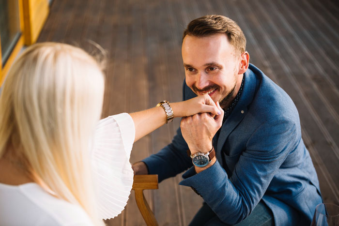 Man proposing during sister's wedding, holding woman's hand and smiling, capturing a moment of a wedding proposal. Man proposing during sister's wedding, holding woman's hand and smiling, capturing a moment of a wedding proposal.