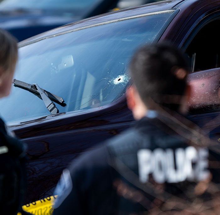 Police officers inspecting a car with a bullet hole in the windshield linked to woman slain by ICE in Minneapolis case. Police officers inspecting a car with a bullet hole in the windshield linked to woman slain by ICE in Minneapolis case.