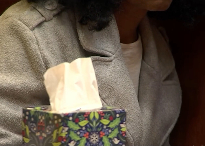 Person in gray coat holding a colorful tissue box, relating to five-year-old&rsquo;s chilling last words before disappearance.
