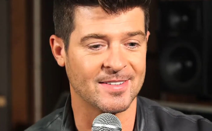 Male celebrity speaking into a microphone in a studio setting related to celebrity infidelity scandals discussion.