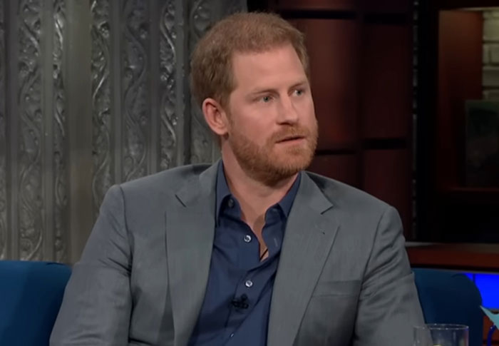 Male celebrity with red hair and beard wearing a gray suit and blue shirt during a talk show interview about being out of touch.