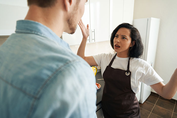 Angry chef girlfriend arguing with boyfriend in kitchen, showing frustration about not going to restaurants together. Angry chef girlfriend arguing with boyfriend in kitchen, showing frustration about not going to restaurants together.