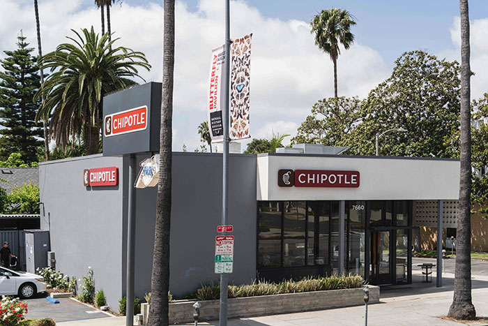 Chipotle restaurant exterior with palm trees in a sunny setting, related to billionaires and Bill Ackman donation controversy. Chipotle restaurant exterior with palm trees in a sunny setting, related to billionaires and Bill Ackman donation controversy.