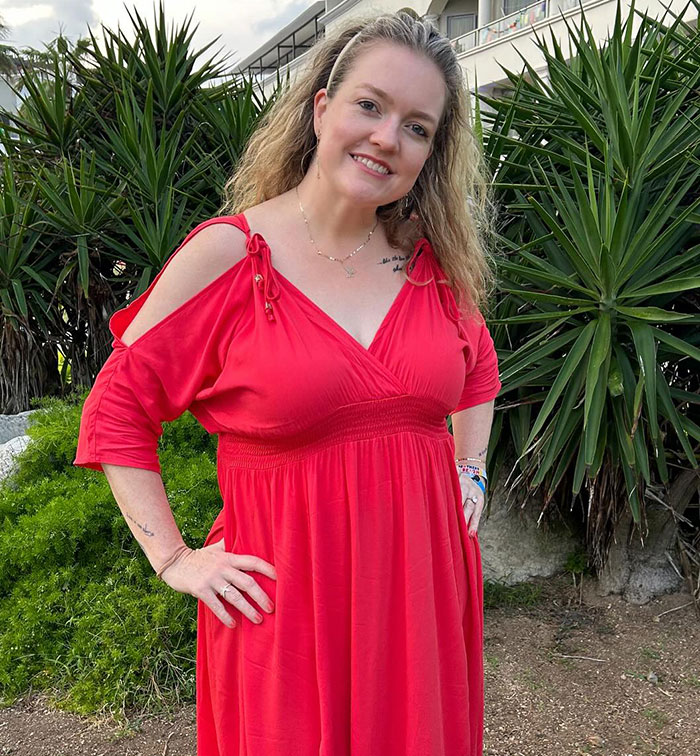 Woman in red dress outdoors with greenery, related to Ryan Reynolds manipulative email leak to Colleen Hoover.