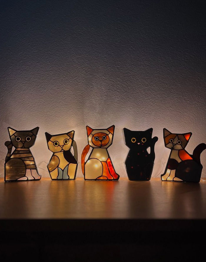 Stained glass cat figurine lights glowing softly on a wooden surface showcasing cool interior design ideas.
