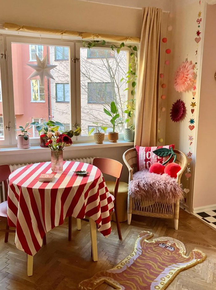 Cozy interior design ideas featuring a striped tablecloth, plants, colorful cushions, and decorative wall hangings in a bright room.