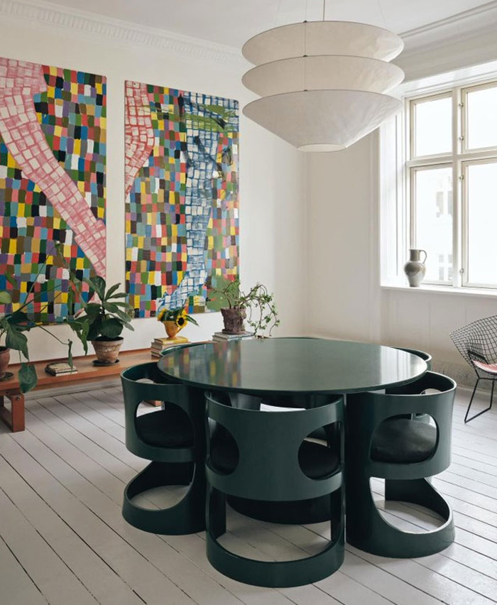 Modern interior design ideas featuring a round table with unique chairs and colorful abstract wall art in a bright room.