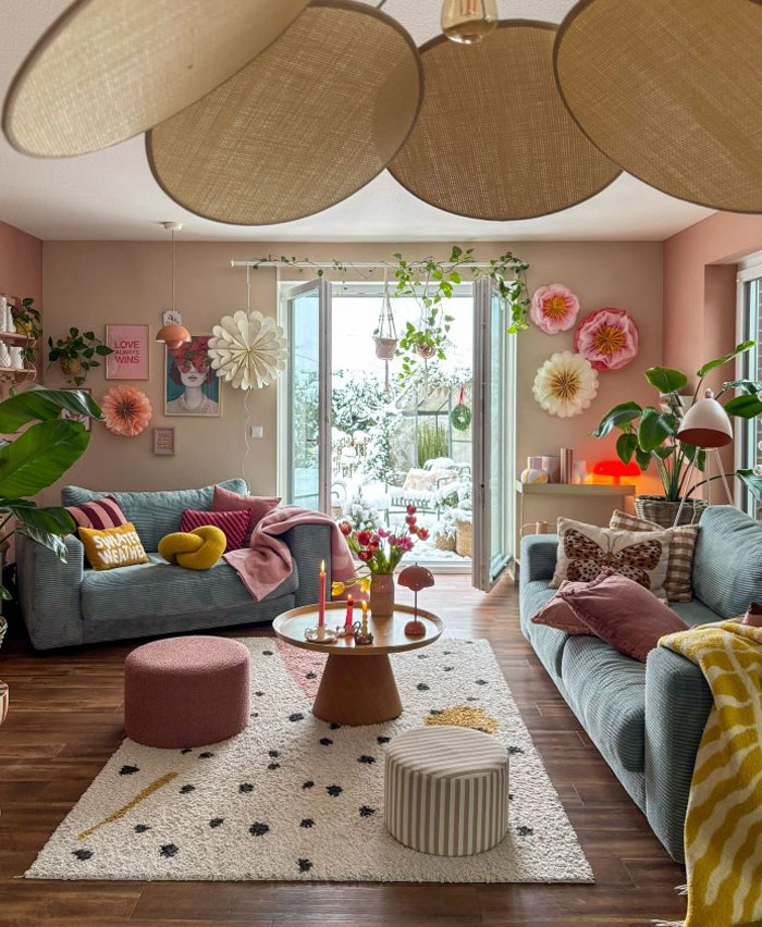 Cozy living room showcasing cool interior design ideas with pastel tones, vibrant pillows, plants, and artistic decor elements.