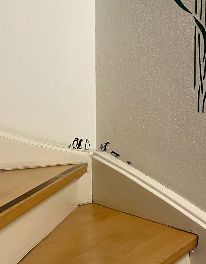 Small penguin wall art on stair corner showcasing cool interior design ideas for a unique home decor touch.
