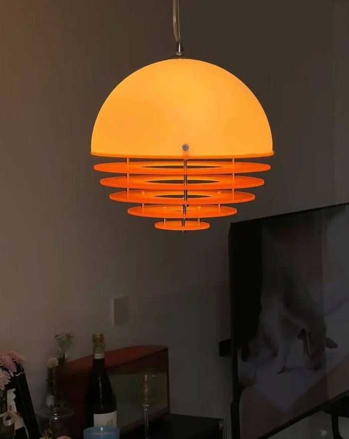 Modern orange pendant light fixture illuminating a stylish room, showcasing cool interior design ideas for home decor.