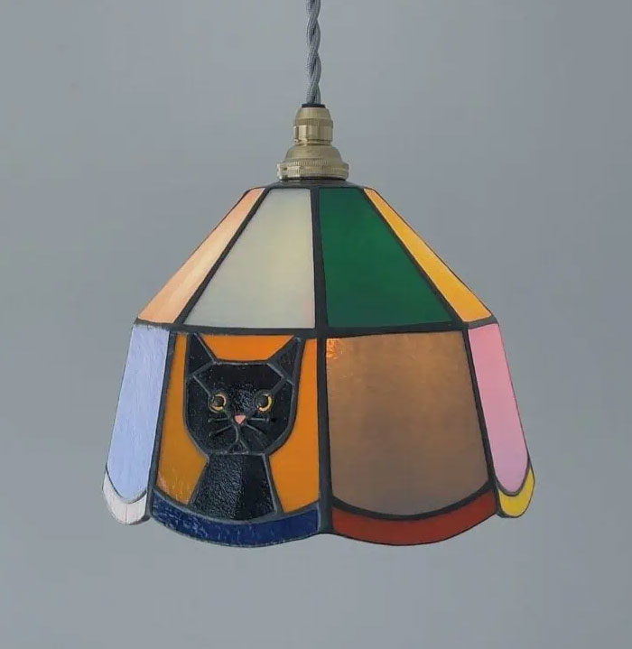 Stained glass pendant light with a colorful geometric design featuring a cat, a unique cool interior design idea.