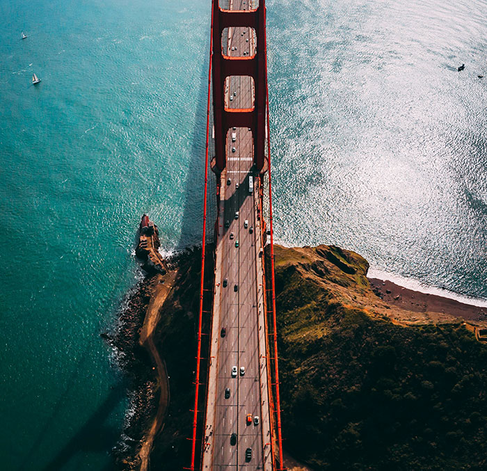 Aerial view of Golden Gate Bridge over turquoise water and cliffs, travel cities: Tokyo.