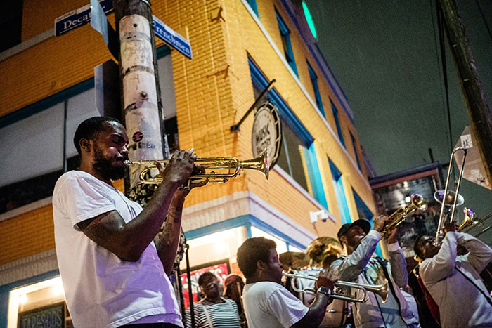 Brass band playing trumpets on a nighttime city street with crowd, lively Tokyo travel scene