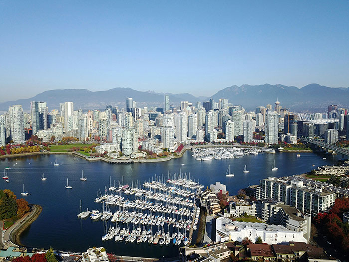Aerial view of a waterfront skyline with marina and sailboats, mountains beyond, includes keyword Tokyo