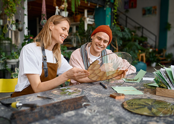 Couple crafting together at a table, sharing fun moments reflecting on dumb house rules they now take seriously.