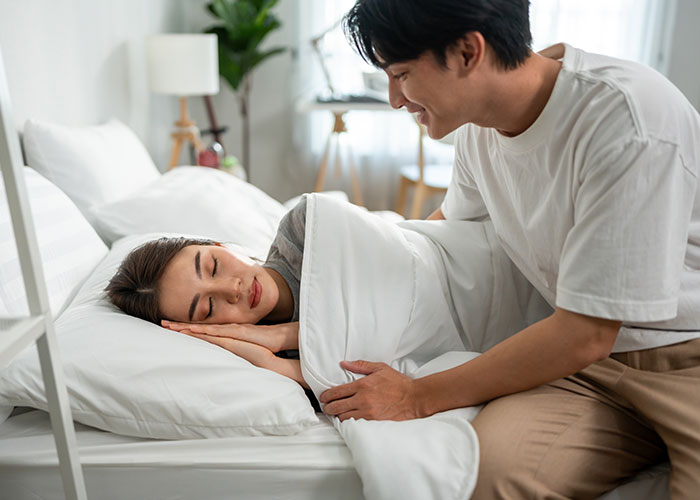 Couple sharing dumb house rules laughing and enjoying playful moments in a cozy bedroom setting