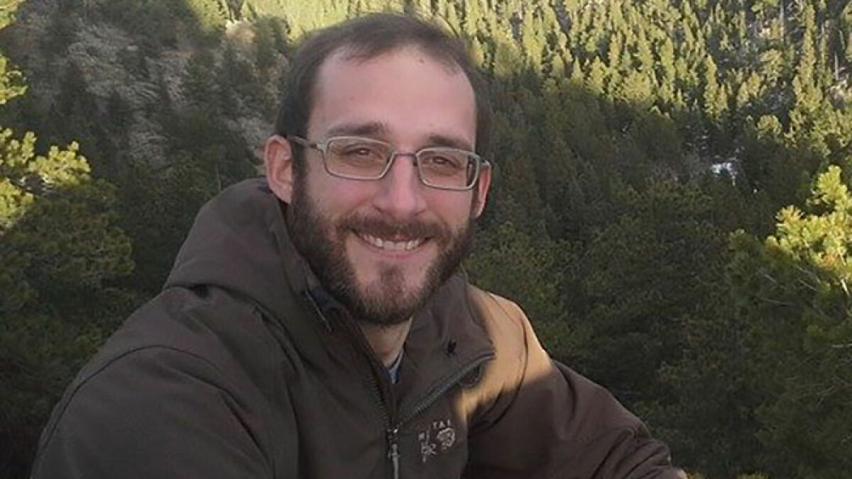 Man with glasses and beard smiling outdoors with trees in the background, related to Alex Prettiu2019s parents learning his fate.